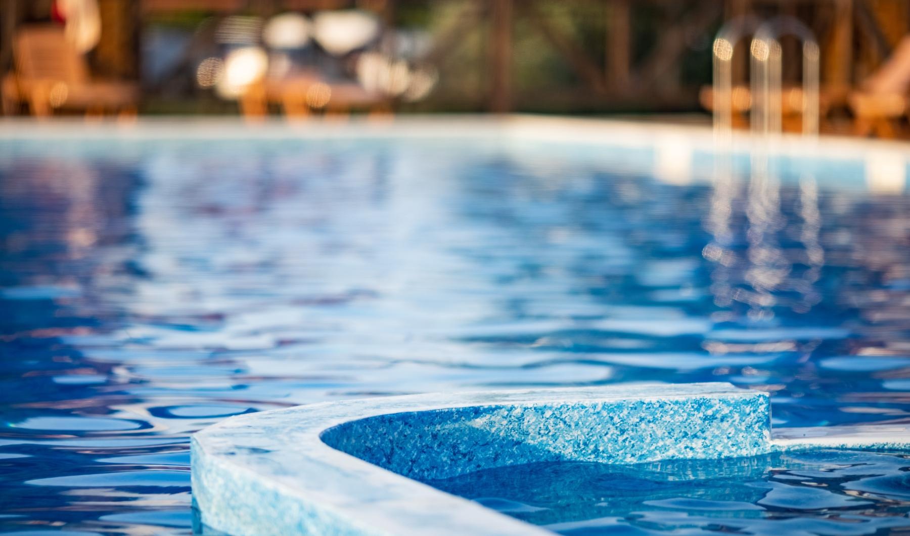 a pool with a blue water fountain