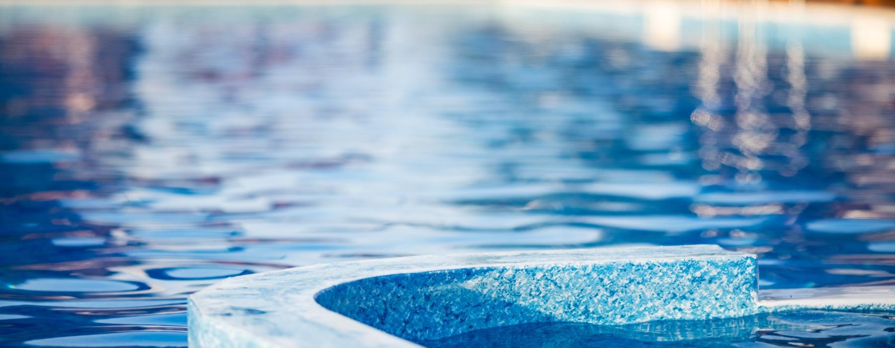 a pool with a blue water fountain